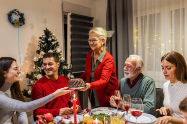 Büyükannem yemek masasına lezzetli bir pasta getirdi. Aile Noel kutlaması.