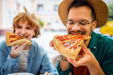 Restorandaki çift ketçaplı lezzetli pizzalar yiyor..
