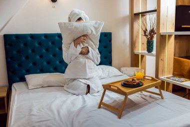 Otel odasında kafasında bornoz ve havlu olan güzel bir kız. Tatilde dinleniyorum..