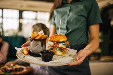 Restoranda servis edilen patates kızartmalı ve ketçaplı lezzetli görünümlü hamburger..