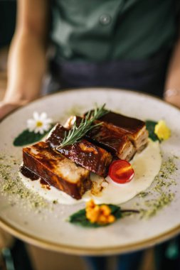 Izgara domuz pirzolası, ızgara sos, baharat, biberiye ve vişneli domates.