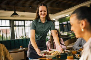 Garson, bir restorandaki misafirlerine sezar salatası olan ilk yemeği getirir..