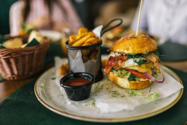 Restoranda servis edilen patates kızartmalı ve ketçaplı lezzetli görünümlü hamburger..