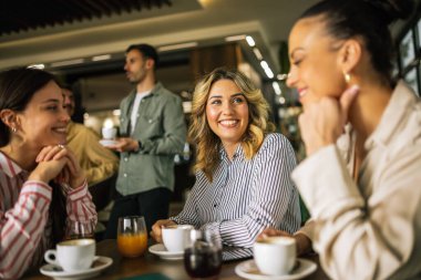 Bir grup bayan arkadaş restoranda kahve içerken arkadaki adamlar flört edip onlara içki göndermeye çalışıyor. Kızlar kıkırdar ve dedikodu yaparlar..