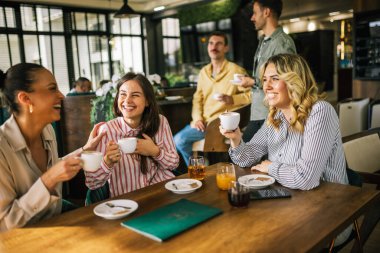 Bir grup bayan arkadaş restoranda kahve içerken arkadaki adamlar flört edip onlara içki göndermeye çalışıyor. Kızlar kıkırdar ve dedikodu yaparlar..