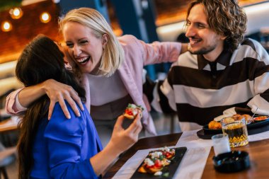 Arkadaşlar birbirlerini restoranda görüp merhaba demek için uğramışlar..