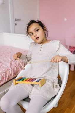 Otizmli kız metalofon çalıyor. Evde müzik terapisi