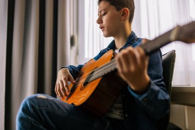 Çocuk evde gitar çalıyor..