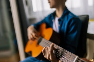 Çocuk evde gitar çalıyor..