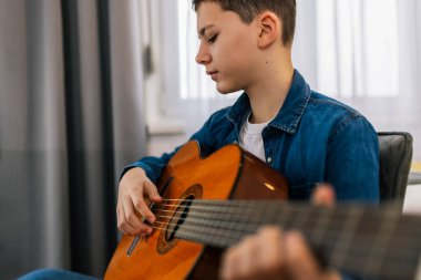 Çocuk evde gitar çalıyor..