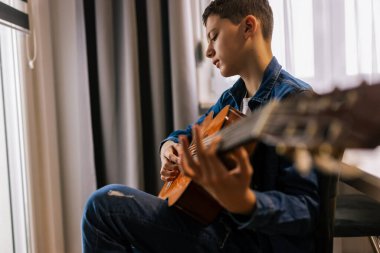 Çocuk evde gitar çalıyor..