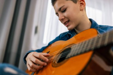 Çocuk evde gitar çalıyor..