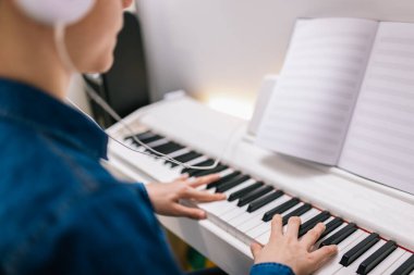 Çocuk evde notalardan piyano çalıyor..