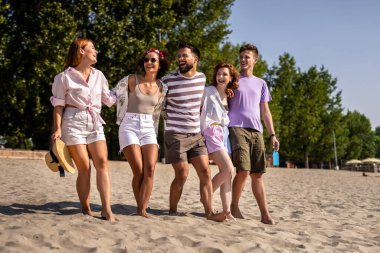 Bir grup arkadaş sahilde birlikte yürüyorlar. Renkli kokteyller içip eğleniyorlar..