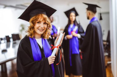 Gigner 'ın Toga' lı öğrencisinin portresi. Arkadaşlarının önünde diplomasını tutuyor..