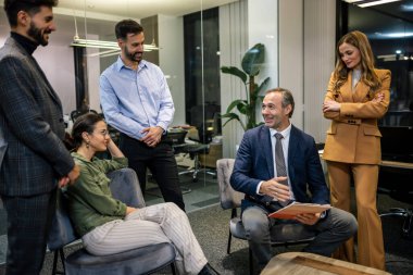 İşçi grubu ve takım lideri toplantı odasında iş yerinde takım çalışması tartışması yürütüyorlar..