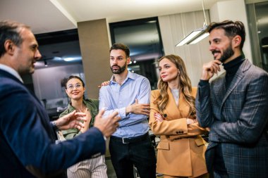 Modern bir ofiste, canlı bir sohbete katılan bir grup iş adamı.