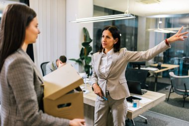 Businesswoman got fired from her job. Taking box with her personal stuff from the office. clipart