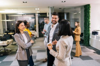 Seminer sırasında kahve molası veren iş adamları. Ofiste dikilip iş hakkında konuşmak..