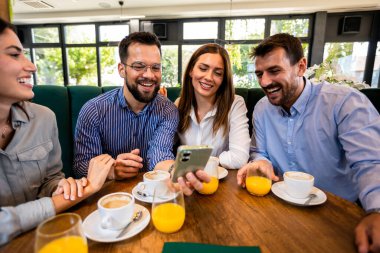 Bir arkadaş grubu kafede buluştu. Telefondaki resimlere bakıyorum. Birlikte eğleniyoruz..