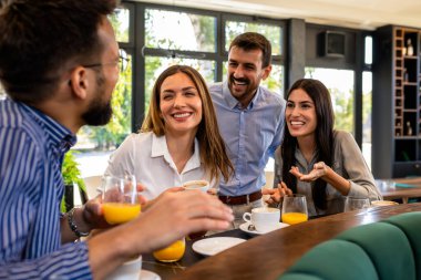 Bir grup arkadaş restoranda buluştu. Takılıyorlar, kahve içip gülüyorlar..