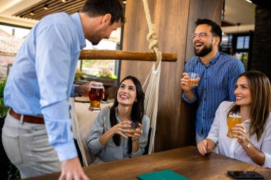 Bir grup arkadaş restoranda buluştu. Takılıyorlar, bira içip gülüyorlar..
