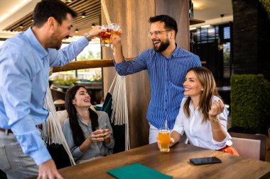 Bir grup arkadaş alkollü bir restoranda kadeh kaldırıyor.