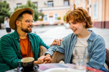 Turist çift bir kafede oturuyor. El ele tutuşun ve birbirinizle konuşun. Şehri keşfetmeye ara verdim..