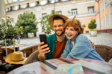 Turist çift keşfettikleri yeni şehrin restoranında selfie çekiyor..