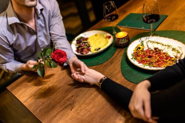 Sevgili sevgili sevgilisine romantik bir akşam yemeğinde kırmızı bir gül hediye eder..