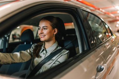 Yeraltı garajında park yeri arayan genç bir kadın. Arabasıyla geziyor..