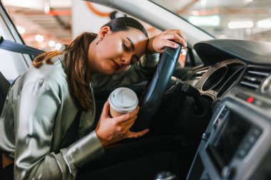 Woman fell asleep in her car. Tired of driving around the parking lot. clipart