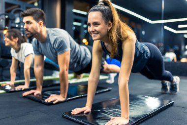 Bir grup sportif insan kalas egzersizi yapıyor..