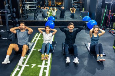 Kas antrenmanı yapan bir grup insan.