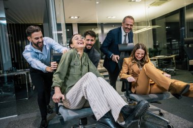 Playful scene in a modern office with businesspeople engaging in a friendly competition. In the image, colleagues are playfully pushing each other on office chairs. clipart