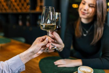 Genç çift romantik bir akşam yemeğinde şarapla kadeh kaldırıyor..