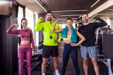 Spor salonundaki dört formda insan kollarını esnetiyor..