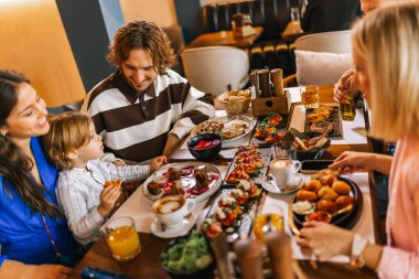 Üç kişilik bir aile lezzetli bir restoranda yemek yiyor. Yiyecek ve içecek konsepti.