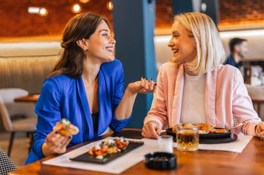 Restoranda birbirleriyle konuşan gülümseyen lezbiyen çift..