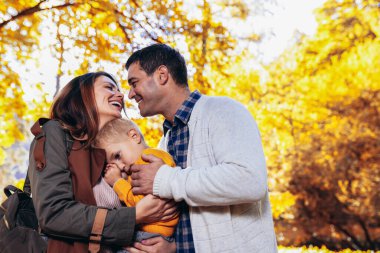 Güzel sonbahar Park'ta yürüyordunuz çocuk ile mutlu aile.