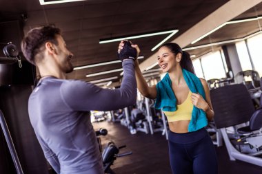 Spor salonunda iyi bir antrenmandan sonra iki fit insan beşlik çakar..
