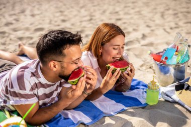 Kumsalda karpuz yiyen iki arkadaş..