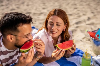 Kumsalda karpuz yiyen iki arkadaş..
