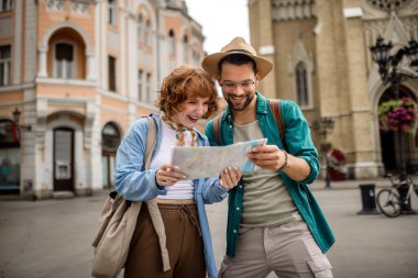 Genç bir çift yeni şehri gezmek için bir harita kullanıyor..