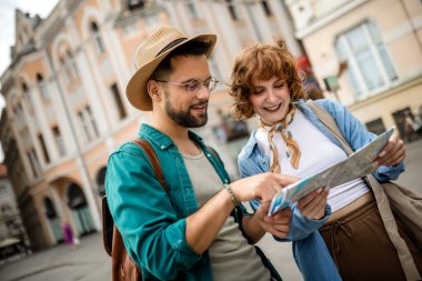 Genç bir çift yeni şehri gezmek için bir harita kullanıyor..