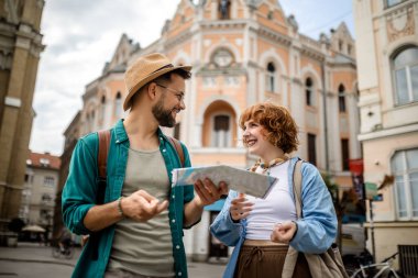 Genç bir çift yeni şehri gezmek için bir harita kullanıyor..