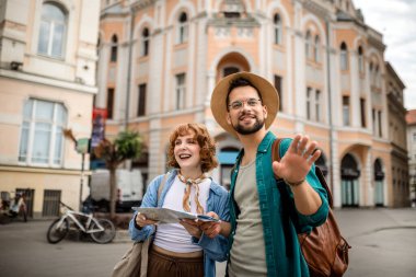 Genç bir çift yeni şehri gezmek için bir harita kullanıyor..