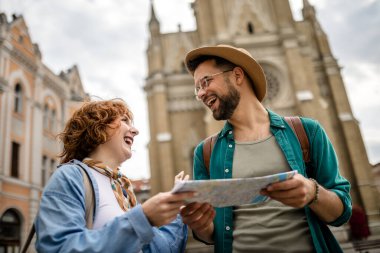 Genç bir çift yeni şehri gezmek için bir harita kullanıyor..