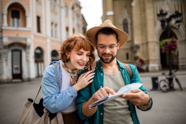 Genç bir çift yeni şehri gezmek için bir harita kullanıyor..