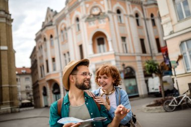 Genç bir çift yeni şehri gezmek için bir harita kullanıyor..